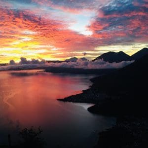 Shades of red and yellow fill the mountain valley at sunrise.
