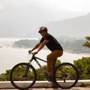 Man resting on his bike with a view of Lake Atitlan behind.