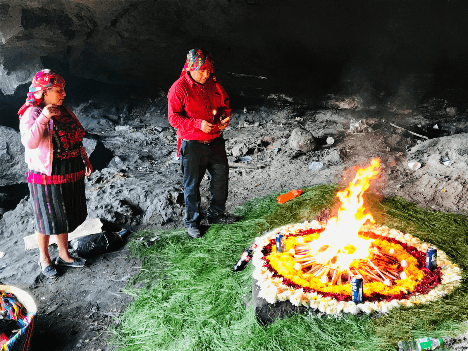 Mayan shaman and his assistant stood around a newly-lit fire inside the sacred caves